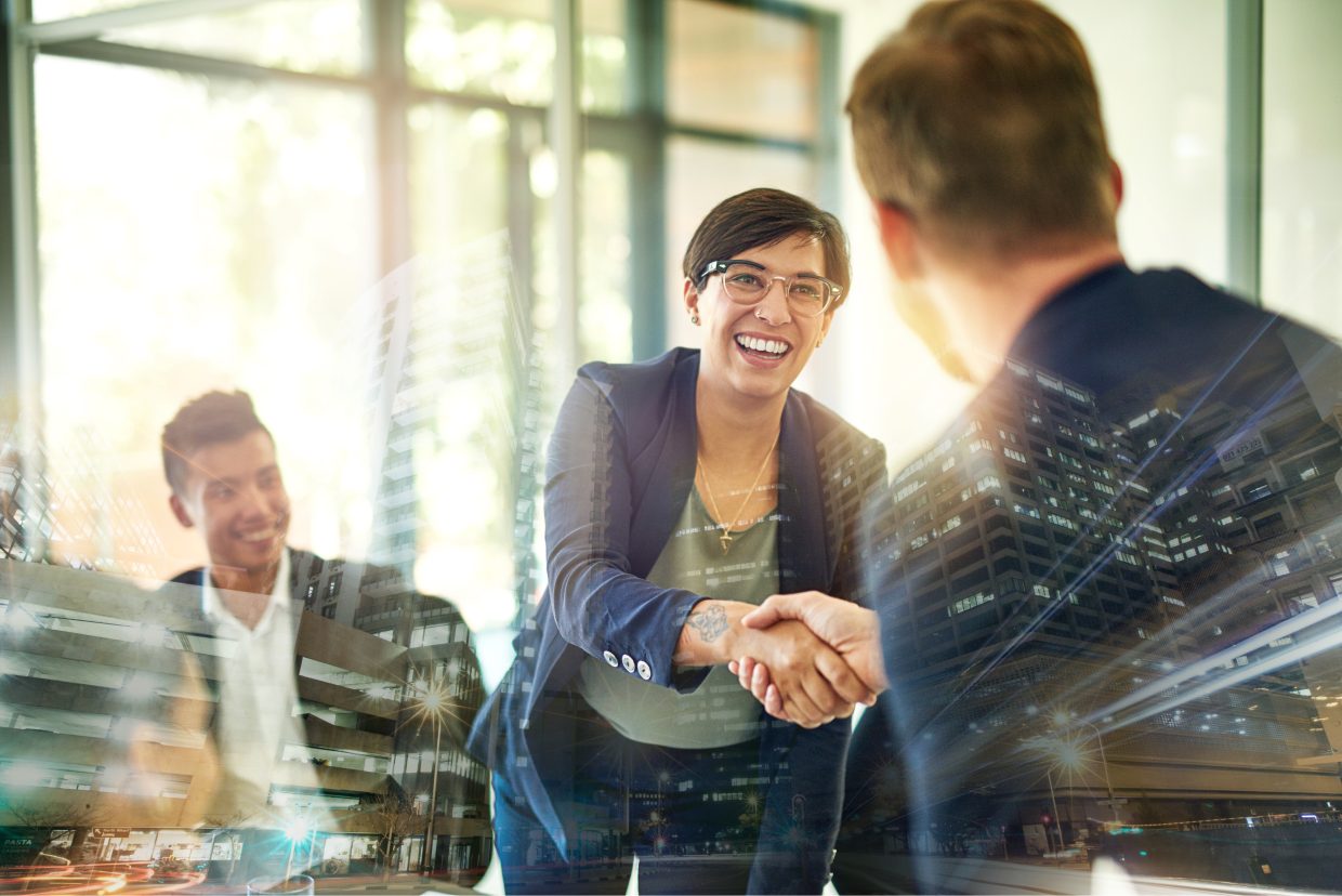 Professional woman shaking hands to symbolize a new hire and team collaboration.